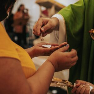 person in white long sleeve shirt holding gold ring